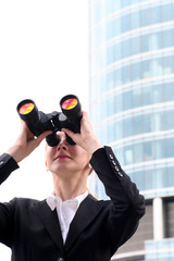 Businesswoman looking through binoculars