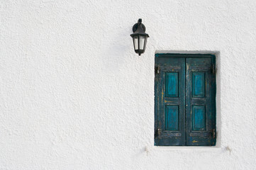 Abstract close-up of Santorini home wall, window and lamp.