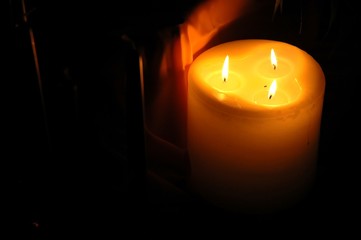 candle with three flames in dim light