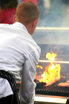cook in white suit preparing barbecue