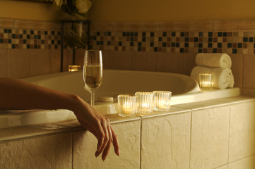 Woman relaxes in the marble tiled bath tub.