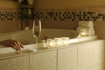Woman relaxes in a marble tiled bath tub.