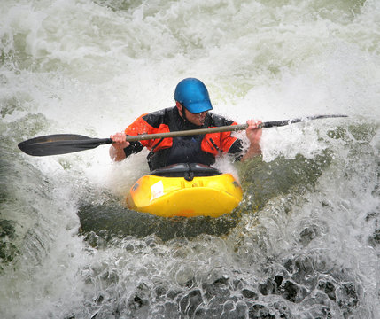 Man Paddling His Kayak On Whitewater Rapids