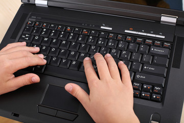 Hands typing on a laptop keyboard