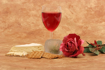Red wine, crackers, cheese, rose and candles