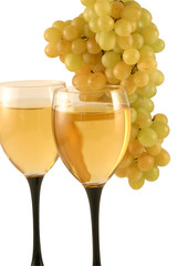 Two glasses of white wine and grapes isolated on white .
