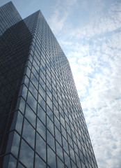 Fototapeta na wymiar Skyscraper Reflects Cloudy Blue Sky
