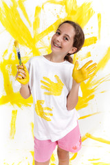 Jeune fille peint un mur en jaune