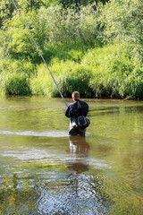 The fisherman fishes in the small river