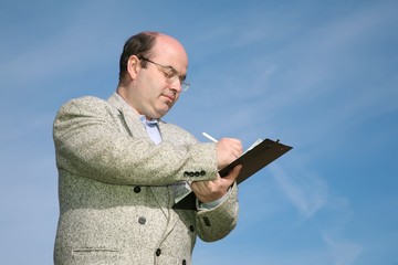 businessman making notes against a sky