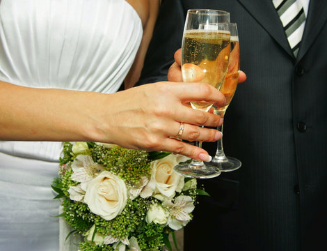 Glasses with a champagne at a newly-married couple