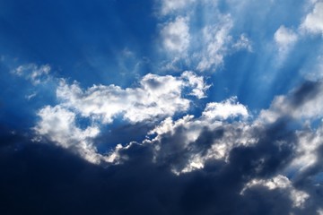 Sun behind heavy clouds with sunrays
