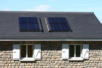 Fototapeta premium Toit gris avec deux panneaux solaires de chauffage