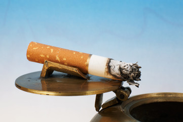 Stub of a cigarette on a bronze ashtray