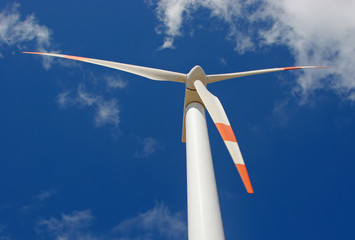 up perspective of wind mill power generator against blue sky