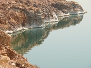 Dead Sea rocky salty coastline, unruffled sea water surface