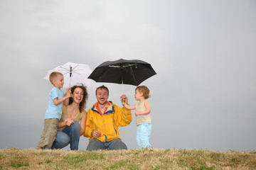 family on the meadow in a rainy day