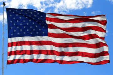 Fototapeta premium American Flag in Bright Blue Sky