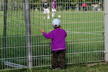 Zaungast kleiner Junge schaut beim Fu&szlig;balltraining zu
