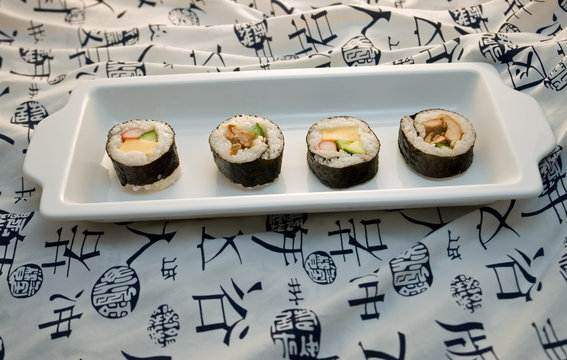 sushi rolls on rectangle plate with white kimono background