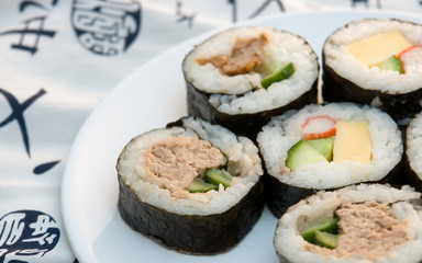 right aligned sushi rolls on plate with kimono background