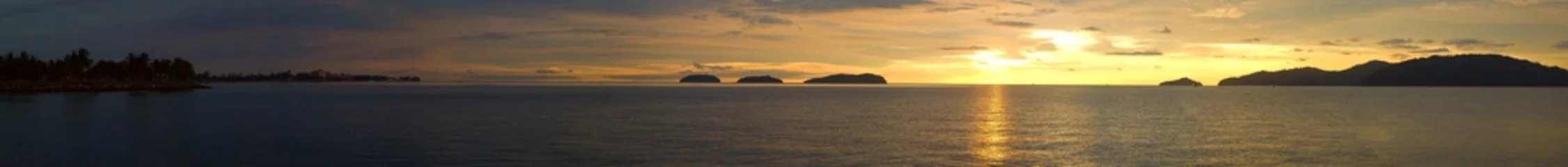 Abwaschbare Fototapete Meer / Ozean Ein ultraweiter Panoramablick auf einen goldenen Sonnenuntergangsozean