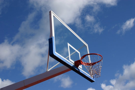 Basketball basket on cloudy sky background.