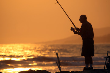 Man fishing at sunset in Malibu