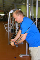 Man exercising shoulders in the gym