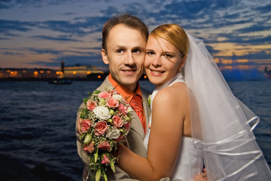 Just married couple near the river at sunset time