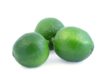 Three green limes on white background