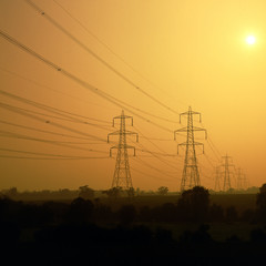 Electricity power lines and pylons in sunset