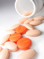 closeup of pills spillt from bottle