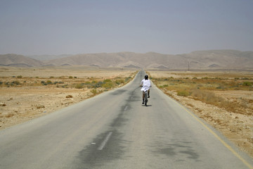 Fototapeta premium man cycling on sede boker desert road, israel
