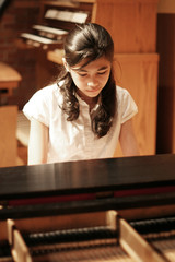 Young teen girl playing the grand piano