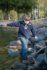 boy on stones near water