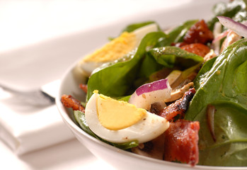 Spinach salad with bacon, mushrooms, onions and egg