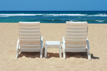 Two beach chairs on beach sand