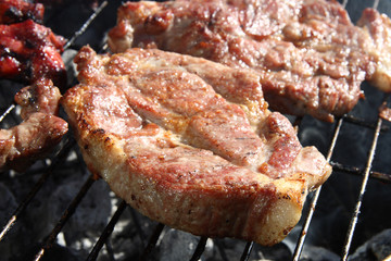 thick seasoned pork chops cooking on the grill