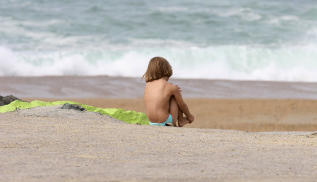 petit gar&ccedil;on seul qui regarde la mer