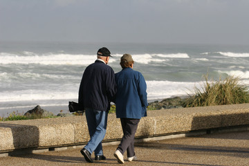 couple de retraités qui marchent en bord de mer