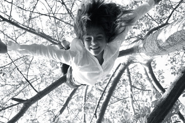 a girl swinging upside down from a tree 