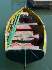 Open fishing dinghy in harbour tied up