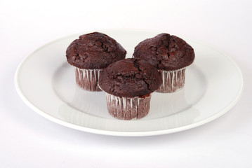 Three chocolate chip muffin cup cakes on white background