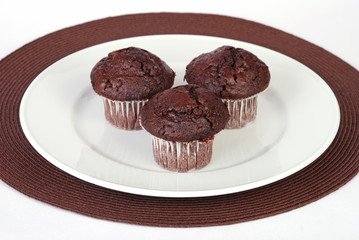 Chocolate chip muffin on plate and table mat