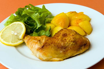 gebratene hähnchenkeule mit salat und bratkartoffeln