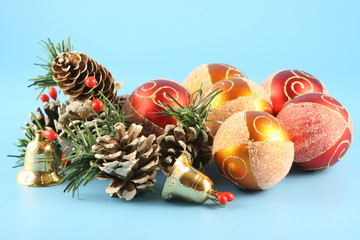 Ñhristmas cones, balls and handbells on a blue background.