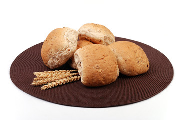Granary bread rolls with wheat in the foreground