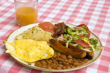 healthy breakfast of eggs, bacon, sausages and juice