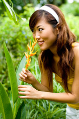 Beautiful asian smelling a flower